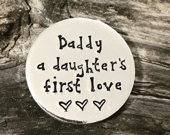 May include: Silver round charm with the text "Daddy a daughter's first love" and three heart symbols.