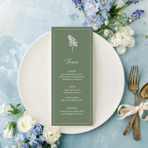 May include: A menu card with the name "Louisa" in elegant script, featuring a floral design. The menu is on a white plate, with vintage silverware tied with a ribbon. Blue and white flowers surround the plate, set against a light blue background.