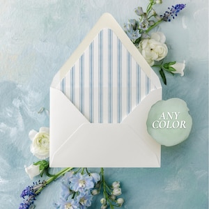 May include: A white envelope with a blue striped interior, surrounded by white and blue flowers, and a green tag that says "ANY COLOR" on a light blue background. The envelope is open, revealing the striped pattern.