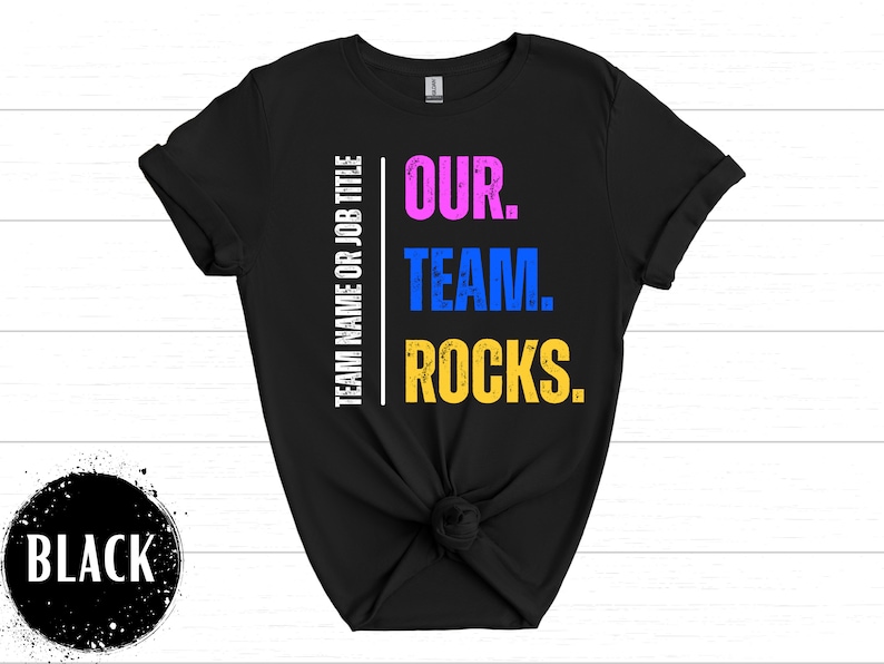 May include: Black t-shirt with white text that reads "TEAM NAME OR JOB TITLE" on the left side and "OUR. TEAM. ROCKS." in colorful text on the right side.