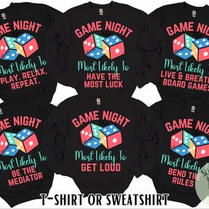 May include: Six black long-sleeved shirts with a white graphic of dice and the text "Game Night" and "Most Likely To" followed by a different phrase on each shirt. The phrases are: "Play. Relax. Repeat.", "Be the Mediator", "Have the Most Luck", "Get Loud", "Live & Breathe Board Games", and "Bend the Rules".