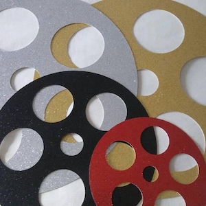May include: Five different sizes of film reel cutouts, made of glitter paper. The cutouts are in silver, gold, black, and red.