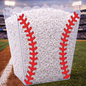 Pode incluir: Recipiente de plástico transparente preenchido com papel branco picado, projetado para se assemelhar a uma bola de beisebol. Detalhe de costura vermelha nas laterais. Perfeito para festas ou eventos com tema de beisebol.
