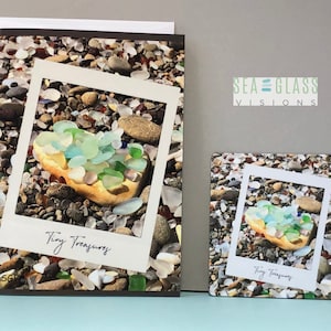 May include: A card and coaster set featuring a photograph of sea glass on a beach. The image is framed in a Polaroid-style frame and the text "Tiny Treasures" is written below the image. The card and coaster are both decorated with the text "Sea Glass Visions".
