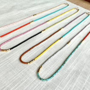 Necklaces laying flat on a cloth.