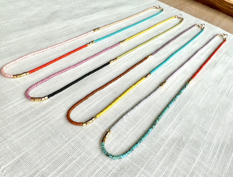 Necklaces laying flat on a cloth.