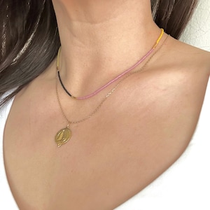 MOdel wearing thin beaded neckalce, layering neckalce.