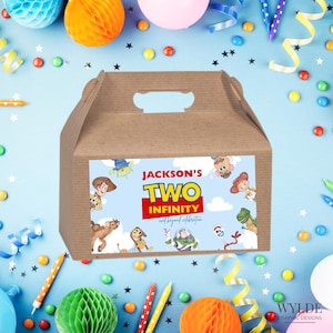 May include: A brown cardboard gift box with a handle, decorated with a colorful label featuring characters and the text "Jackson's Two Infinity and beyond celebration". The box is surrounded by party decorations.