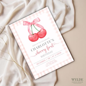 Puede incluir: Una invitación con estampado de cuadros vichy rosa y blanco con una ilustración de acuarela de dos cerezas rojas con un lazo rosa. El texto dice "Únete a nosotros para celebrar el primer cumpleaños de Charlotte, 12 de diciembre a las 2:00 PM, 1234 Willow Rd, City, State zip code, rsvp al 123-456-7891".