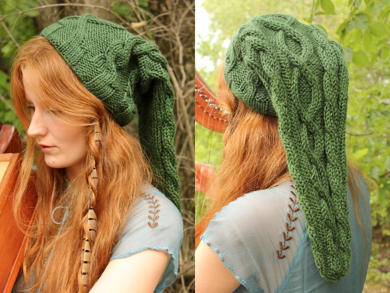May include: A green knitted hat with a long, pointed tail. The hat features a cable knit pattern and is being worn by a person with long, red hair.