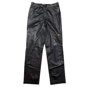 Könnte beinhalten: Schwarze Lederhose mit geradem Bein. Die Hose hat eine hohe Taille und einen Knopf- und Reißverschluss. Der Markenname "MIXIT" ist auf dem Bund sichtbar. Das Leder hat eine leicht strukturierte Optik.