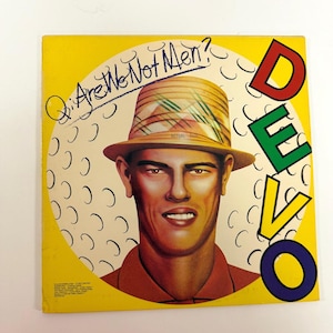 May include: A vintage album cover for the band Devo. The cover features a stylized portrait of a man wearing a straw hat, with the band's name in colorful letters. The album title, "Q: Are We Not Men?" is written above the portrait.