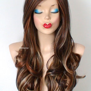 May include: Long brown wig with blonde highlights and loose curls. The wig is styled with a side part and falls to the shoulders.
