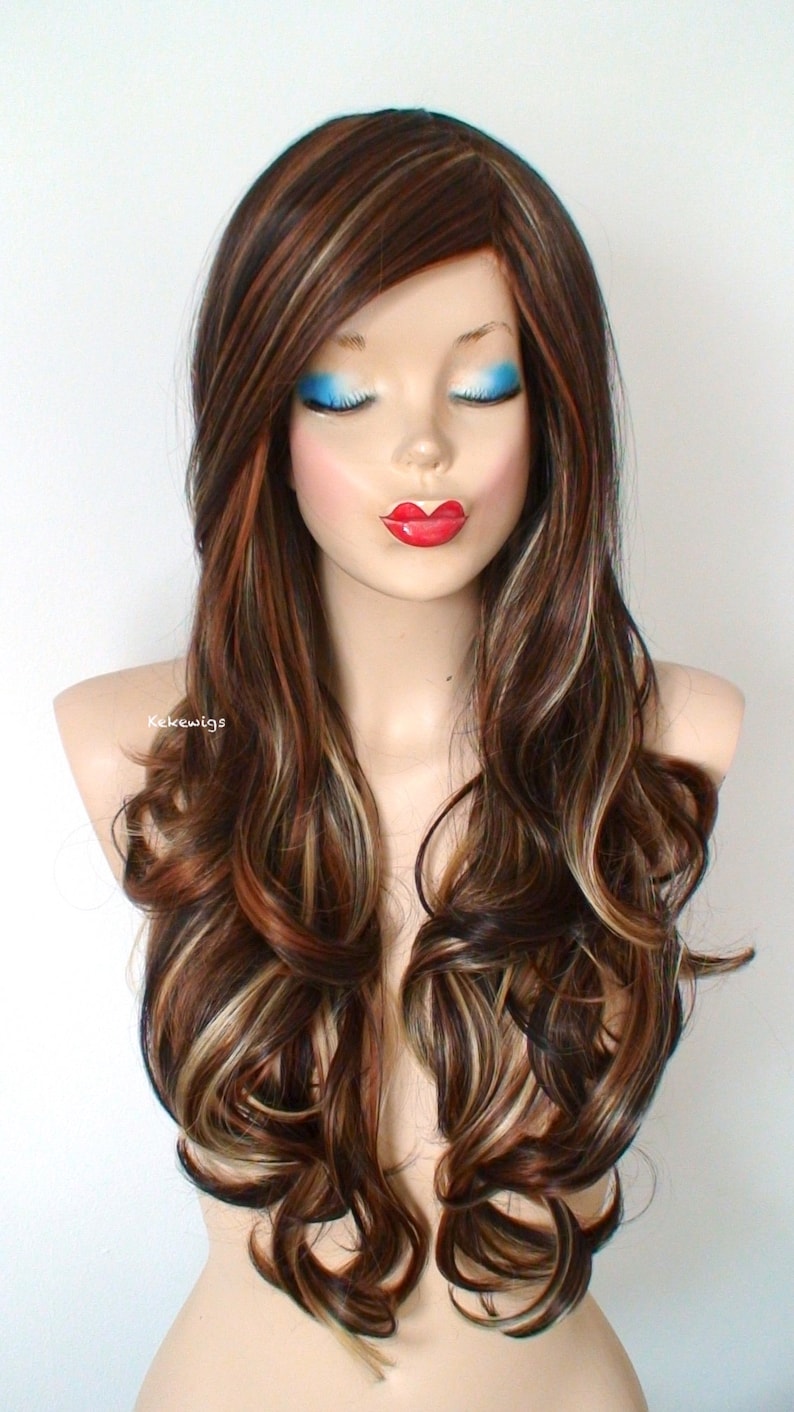 May include: Long, wavy brown wig with blonde highlights. The wig is styled with loose curls and a side part. The wig is on a mannequin head.