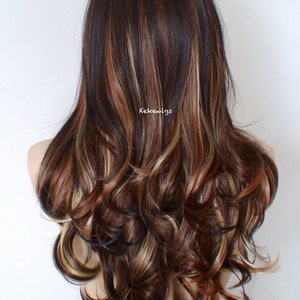 May include: Long, wavy brown wig with blonde and reddish highlights. The wig is styled in loose curls and falls to the shoulders.