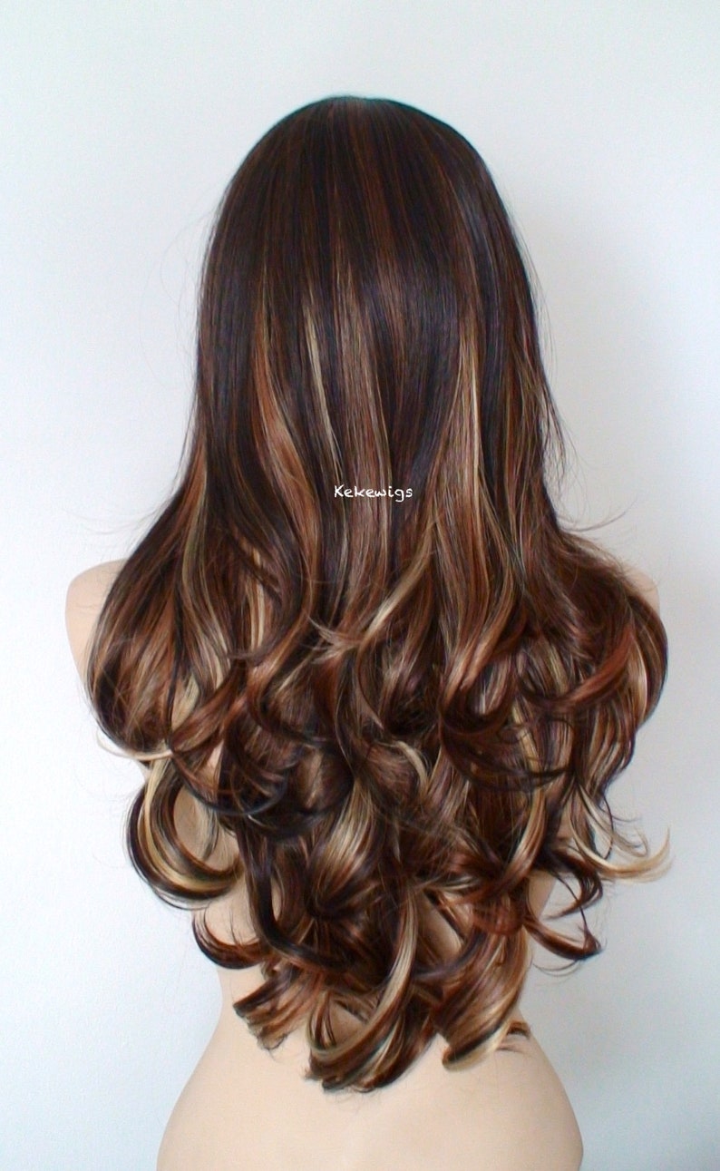 May include: Long, wavy brown wig with blonde and reddish highlights. The wig is styled in loose curls and falls to the shoulders.