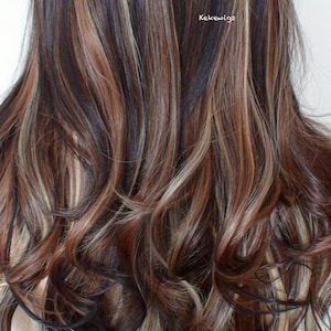 May include: Long, wavy brown hair wig with blonde and reddish highlights. The wig is styled in loose curls and falls to the shoulders.
