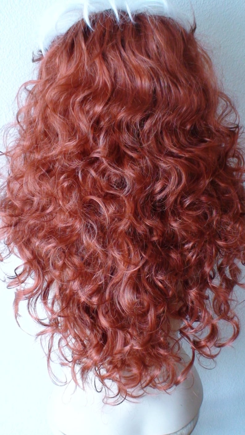 May include: A long, curly, auburn-colored wig with a white wig cap.