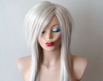 May include: A long, straight, platinum blonde wig with a side part and bangs. The wig is styled with layers and is worn on a mannequin head.