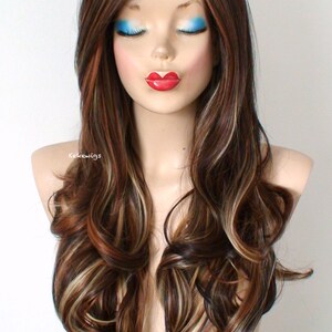 May include: Long, wavy brown wig with blonde highlights. The wig is styled with loose curls and falls to the shoulders.