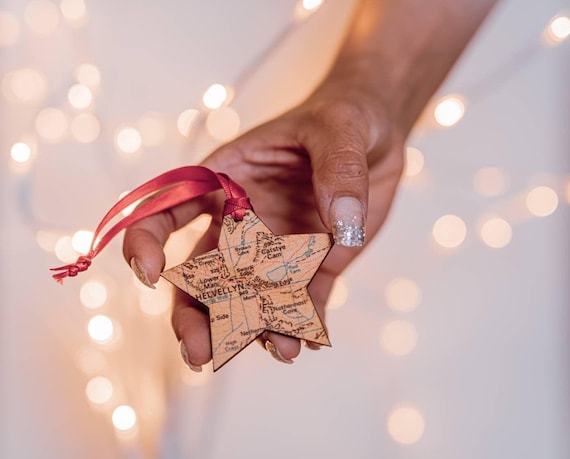A laser-cut wooden star map ornament showing the exact night sky of any date and location — tiny, sustainable, and genuinely sentimental.