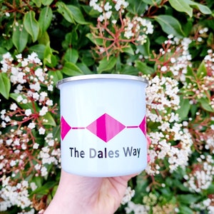 Op de afbeelding: Een witte emaille mok met een roze ruitpatroon en de tekst "The Dales Way".