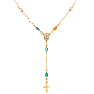 May include: Gold chain necklace with a small cross charm and a pendant featuring the Virgin Mary. The necklace is adorned with colorful oval-shaped stones.