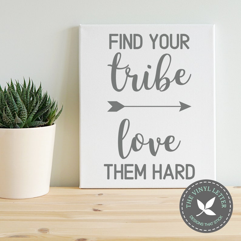 May include: White canvas with gray text that reads "Find your tribe love them hard". An arrow points to the right. A small gray circle with a green leaf logo and the text "The Vinyl Letter Designs That Stick" is in the bottom right corner.