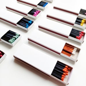 25 White plain matchboxes, black/cinnamon/red wooden sticks, matchboxes with different head color matches/ one head color per matchbox