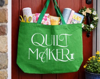 La bolsa de transporte para acolchado QUILT MAKER, de color verde, tiene capacidad para colchas grandes, guata, tela y suministros de acolchado, ideal para visitas a tiendas y retiros de acolchado.