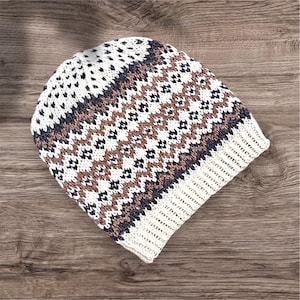 May include: White knitted beanie with a brown, black and white geometric pattern.