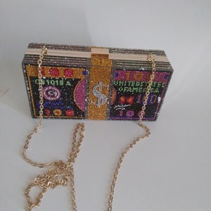 Cartera de mano con joyas (oro negro)