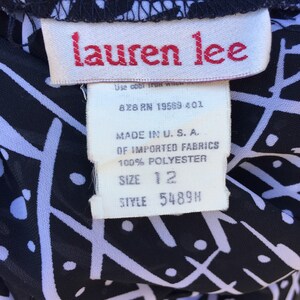 Puede incluir: Una etiqueta blanca con texto negro sobre una tela estampada en blanco y negro. La etiqueta dice "lauren lee", "828 RN 19569-401", "MADE IN U.S.A.", "OF IMPORTED FABRICS", "100% POLYESTER", "SIZE 12" y "STYLE 5489H".