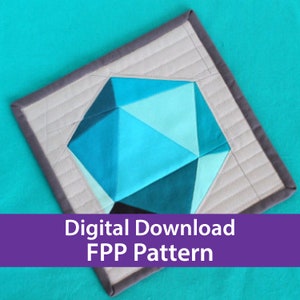 May include: A digital download pattern for a geometric quilt block. The block is made up of a variety of blue and black fabrics, and is set against a gray background. The pattern is called "FPP Pattern".