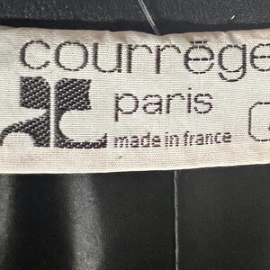 May include: White label with black text that reads "Courr&egrave;ges Paris made in France" and a black logo with the letter "C". The label also has a small white tag with the letter "A" in black.