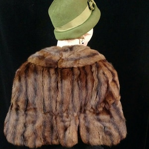 Op de afbeelding: Een bruine bontstola met een brede kraag. De stola is gemaakt van zachte, luxe bont en heeft een klassiek ontwerp.