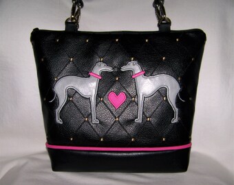 May include: Black quilted tote bag with a pink trim and two grey embroidered dogs facing each other with a pink heart in the middle.