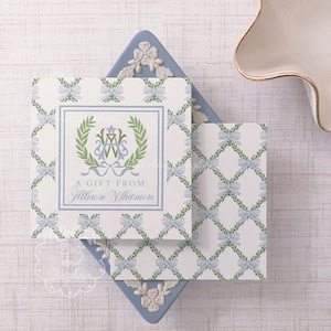 May include: Two gift cards with a trellis pattern of blue bows and green leaves. The cards are on a blue decorative tray. The larger card has a wreath design with the text "A Gift From Allison Whitmore."