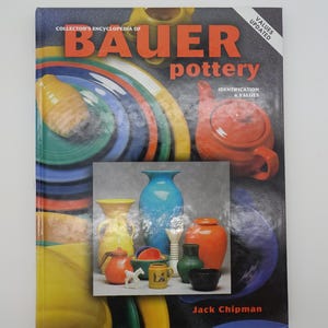May include: A book titled "Collector's Encyclopedia of Bauer Pottery: Identification & Values" with a cover image of colorful pottery, including a blue vase, a red teapot, and a yellow pitcher.