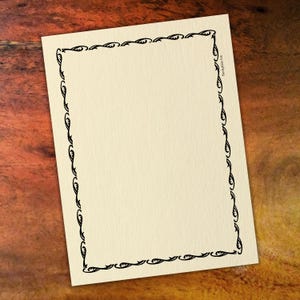 May include: A blank, cream-coloured card with a black decorative border. The border is made up of a repeating pattern of swirls and curves.