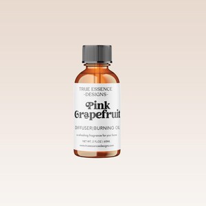 Puede incluir: Una botella de vidrio de aceite de quemador de difusor de pomelo rosa con una etiqueta blanca que dice "TRUE ESSENCE -DESIGNS- Pink Grapefruit DIFFUSER BURNING OIL A refreshing fragrance for your home NET WT: 2 FLOZ 60ML trueessencedesigns.com"