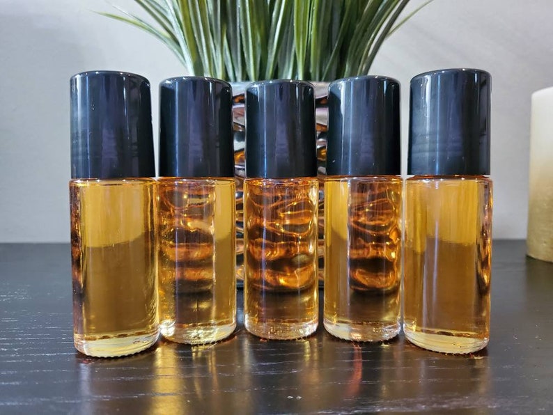 Puede incluir: Cinco botellas de vidrio &aacute;mbar con tapones negros. Las botellas est&aacute;n llenas de un l&iacute;quido transparente y dorado.