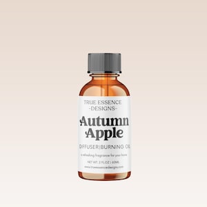May include: A brown glass bottle with a black cap and a white label. The label reads "TRUE ESSENCE -DESIGNS- Autumn Apple DIFFUSER BURNING OIL a refreshing fragrance for your home NET WT. 2 FLOZ 60ML www.trueessencedesigns.com"