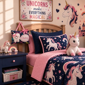 K&ouml;nnte beinhalten: Ein marineblaues Steppdecken-Set mit wei&szlig;en Einh&ouml;rnern, rosa Herzen und Regenb&ouml;gen. Das Set enth&auml;lt ein rechteckiges Kissen mit Einhorn-Motiv, eine passende Tagesdecke und ein dekoratives H&auml;ngekissen mit dem aufgedruckten Namen Aubrey.