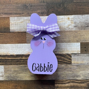 K&ouml;nnte beinhalten: Drei Keramikbecher mit gesprenkelter, cremefarbener Glasur. Jeder Becher zeigt ein handgemaltes Blumendesign in Blau-, Gr&uuml;n- und Gelbt&ouml;nen. Die Becher haben eine einfache, abgerundete Form und einen Griff.