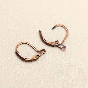 May include: Two antique copper-colored leverback earring findings. Each finding has a curved lever and a loop for attaching a charm or earring component. The findings are designed for secure and easy earring closures.