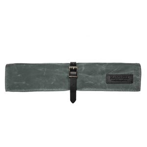 May include: A gray waxed canvas tool roll with a black leather strap and buckle closure. The roll features a black leather patch with the text "HARDMILL". The tool roll is designed to hold tools.