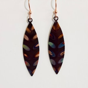 May include: A pair of dangle earrings with a dark brown, leaf-shaped design. The leaves have a multi-colored pattern with shades of green, blue, and pink. The earrings are made of metal and have a rose gold finish.