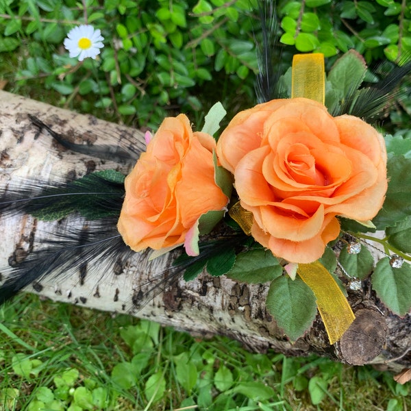 Corsage de fleurs artificielles roses oranges.