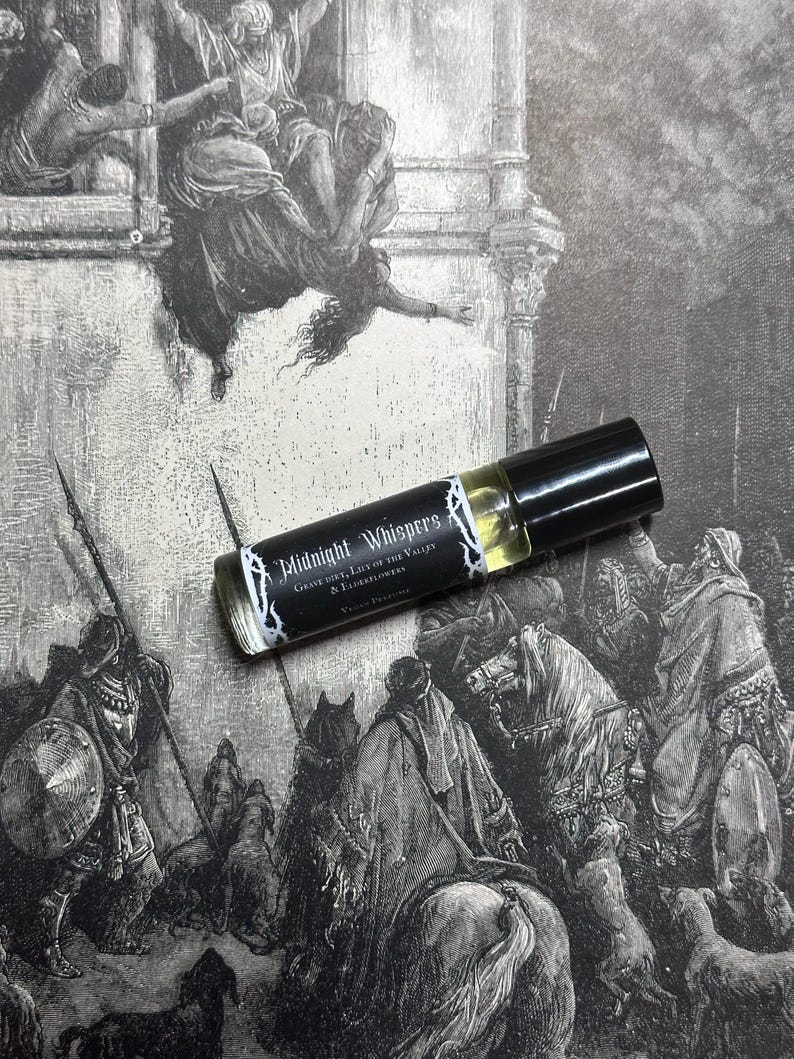 May include: A black and white image of a scene from a book. A small glass bottle with a black cap and a label that reads "Midnight Whispers Grave Dirt, Lily of the Valleys & Elderflowers" is in the foreground.
